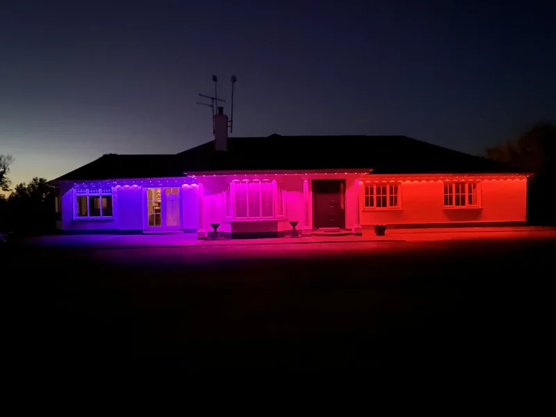 The same real house with blue, purple and red Govee lighting after dusk