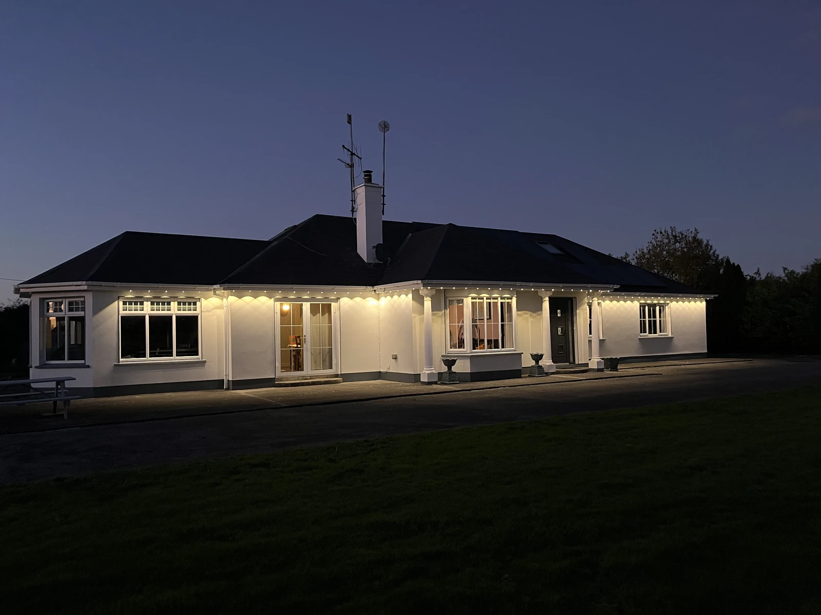 Actual Govee roofline installation with warm-white light along the roofline at dusk